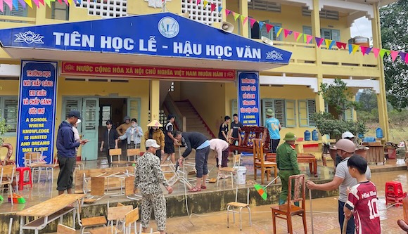 Teachers, police, military and parents clean up mud after the floodwaters receded on September 14. Photo: Ba Long Primary & Secondary School