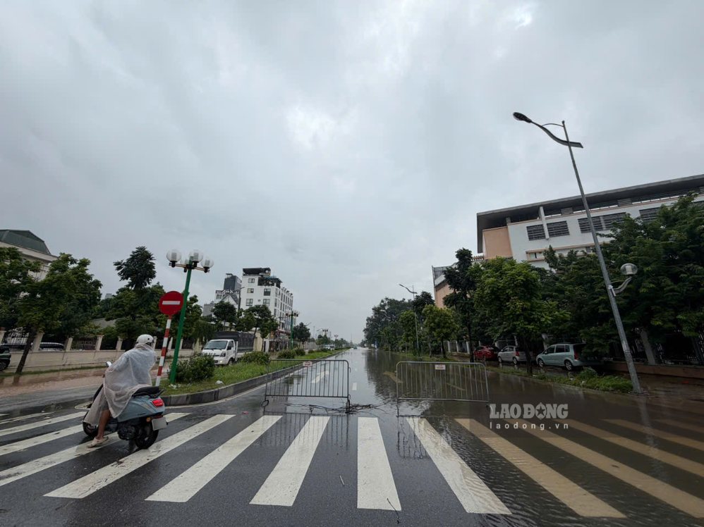 Lực lượng chức năng dựng barie hạn chế phương tiện qua lại điểm ngập úng.