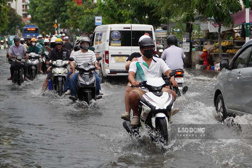 Motorbikes moving through flooded roads in the rainy season. Photo: Thai Bao (taken in September 2026)