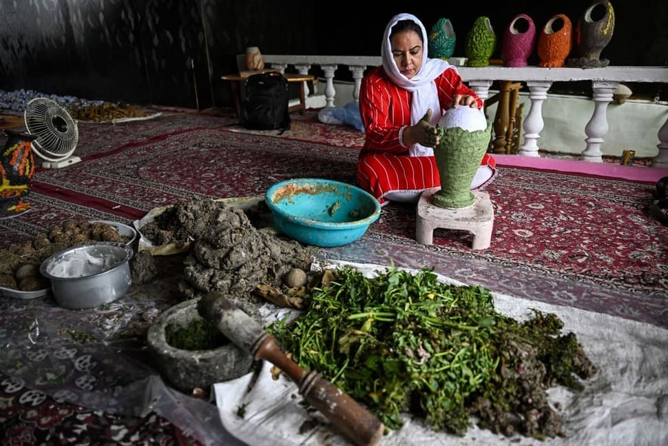 Artisans use dried aquatic plants collected from Dal Lake to make handicrafts in Kashmir, India on August 19, 2026. Photo: AFP