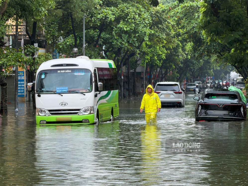 Công nhân Công ty Thoát nước Hà Nội ứng trực, khơi thông dòng chảy tại các điểm úng ngập (ảnh chụp ngày 15.9). Ảnh: Hoài Anh