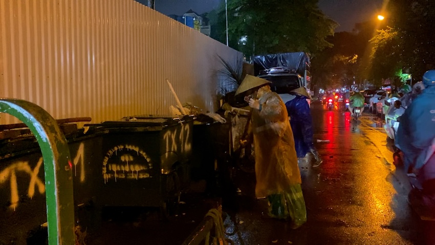 Environmental workers work in the rain, keeping streets clean and beautiful