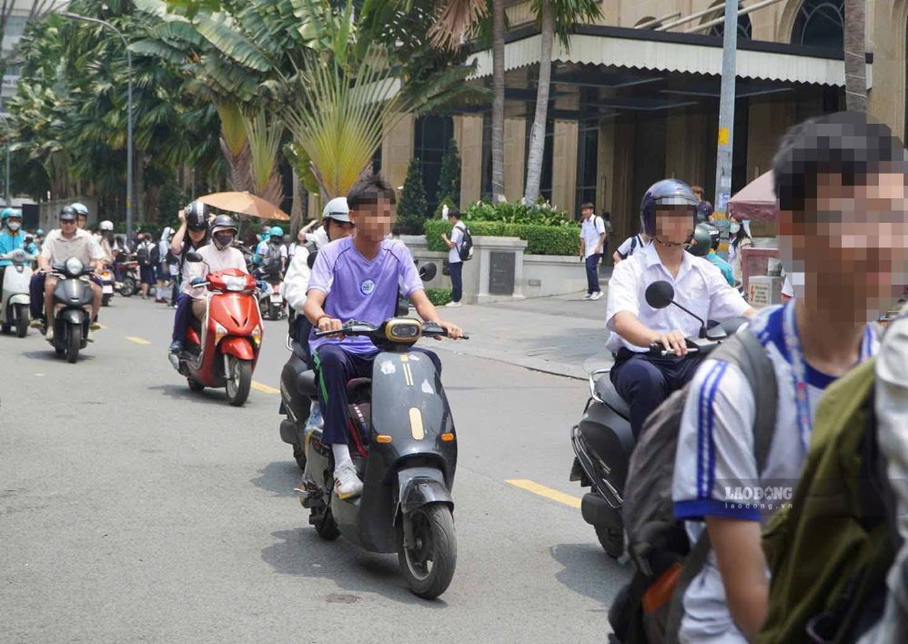 Học sinh không đội mũ bảo hiểm khi điều khiển xe sau giờ tan trường ngày 16.9. Ảnh: Nguyên Chân.