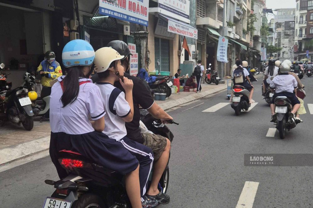 Hình ảnh phụ huynh chở nhiều trẻ cùng lúc, không đội mũ bảo hiểm cho trẻ ngày 15.9. Ảnh: Nguyên Chân.
