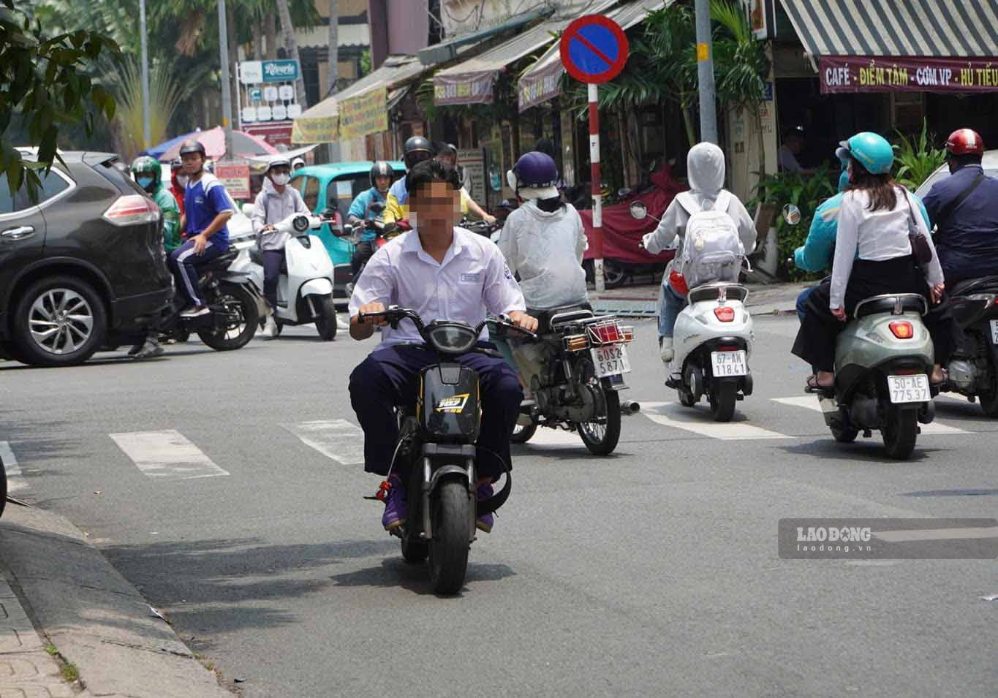 Some students driving electric motorbikes without helmets after school on September 16 in Ho Chi Minh City. Photo: Nguyen Chan