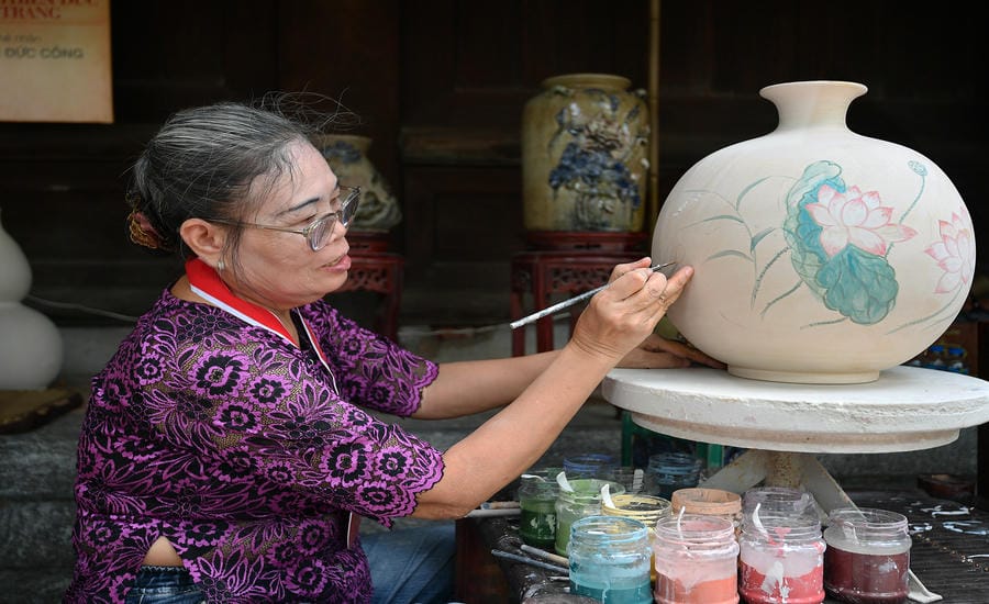 Bà Nguyễn Mỹ Thịnh chăm chút từng nét vẽ trên gốm.