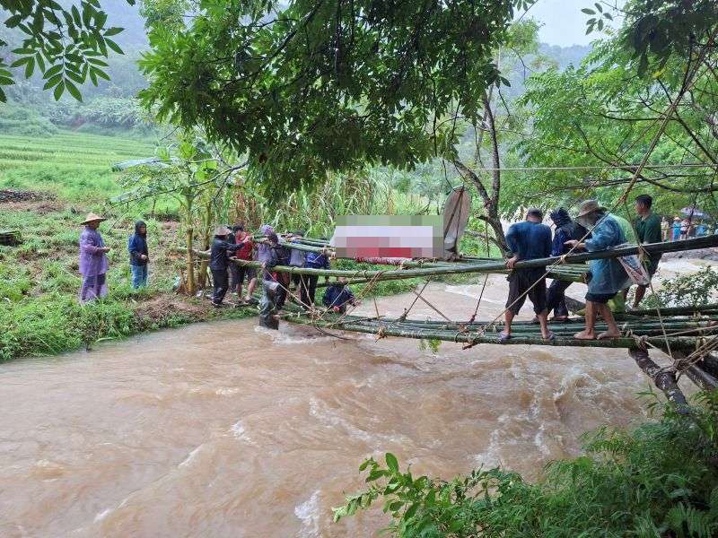 タインホア省プールオンコミューン、タインラム村の住民は、鉄砲水を渡って故人の葬儀を行うための仮設竹橋の建設に集中しています。写真:タインラム村提供