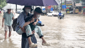 Carrying a patient across the flooded water to be on time to the hospital.