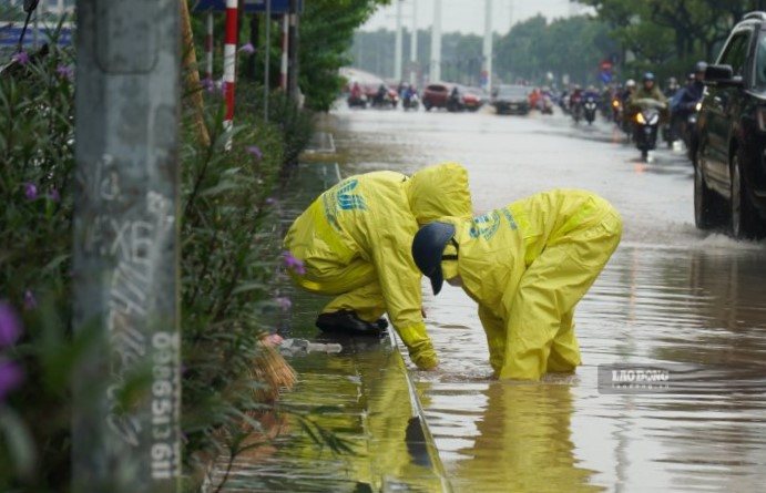 Tại một số điểm, lực lượng chức năng được bố trí để hướng dẫn, phân luồng giao thông, hỗ trợ người dân di chuyển qua khu vực ngập.