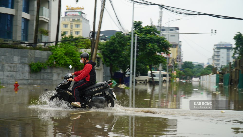 Tại các điểm ngập, nước dâng khiến việc di chuyển của người dân gặp nhiều khó khăn. Xe máy phải giảm tốc độ, một số phương tiện đi qua khu vực ngập có dấu hiệu chết máy.