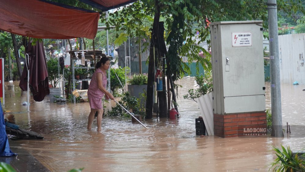 Một số cửa hàng phải kê cao đồ đạc, chủ động ngăn nước tràn vào nhà và đồng thời đẩy bùn đất ra khỏi khu vực trước nhà.