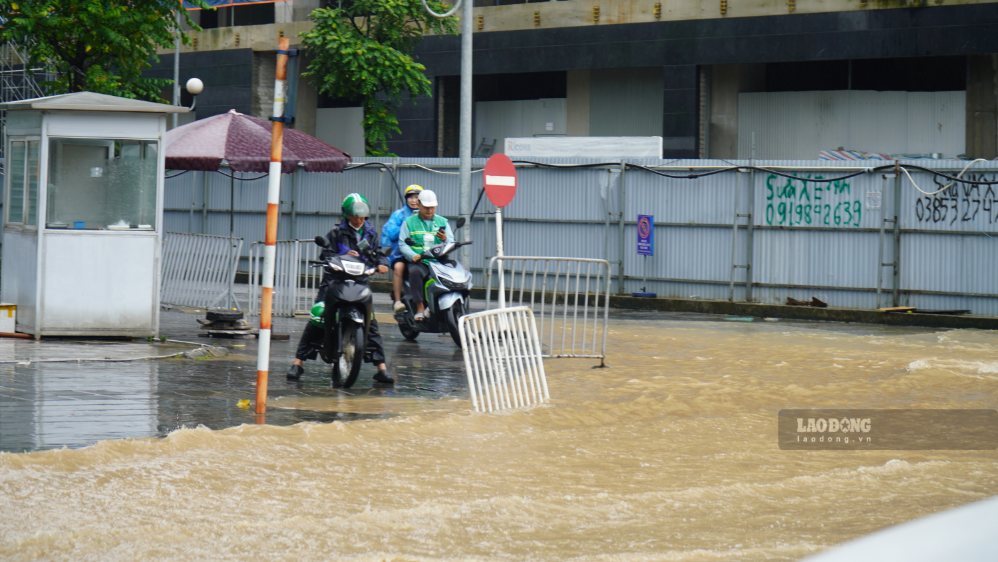 Ghi nhận tại khu vực Mỹ Đình, nước ngập trên mặt đường, có thời điểm khiến các phương tiện phải di chuyển chậm và đi sát vào những khu vực ít ngập hơn.