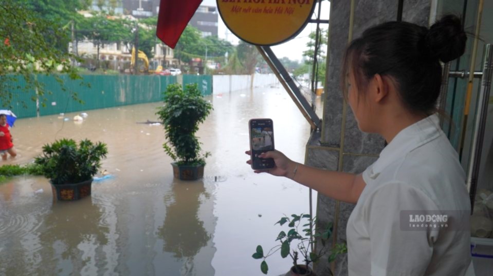 Nước ngập khiến khách hàng khó tiếp cận các cửa hàng trên phố Đồng Me. Ảnh: Minh Vũ
