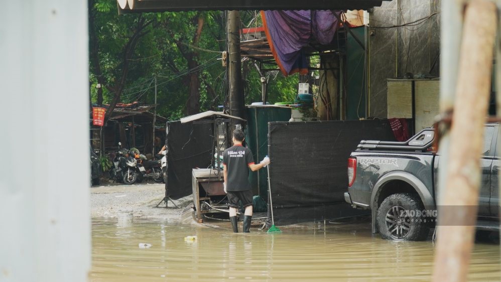 Các hộ kinh doanh tất bật khắc phục ảnh hưởng sau trận mưa lớn. Ảnh: Minh Vũ