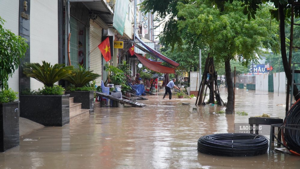 Người dân tất bật dọn dẹp để ổn định sinh hoạt dần trong khi nước rút. Ảnh: Minh Vũ