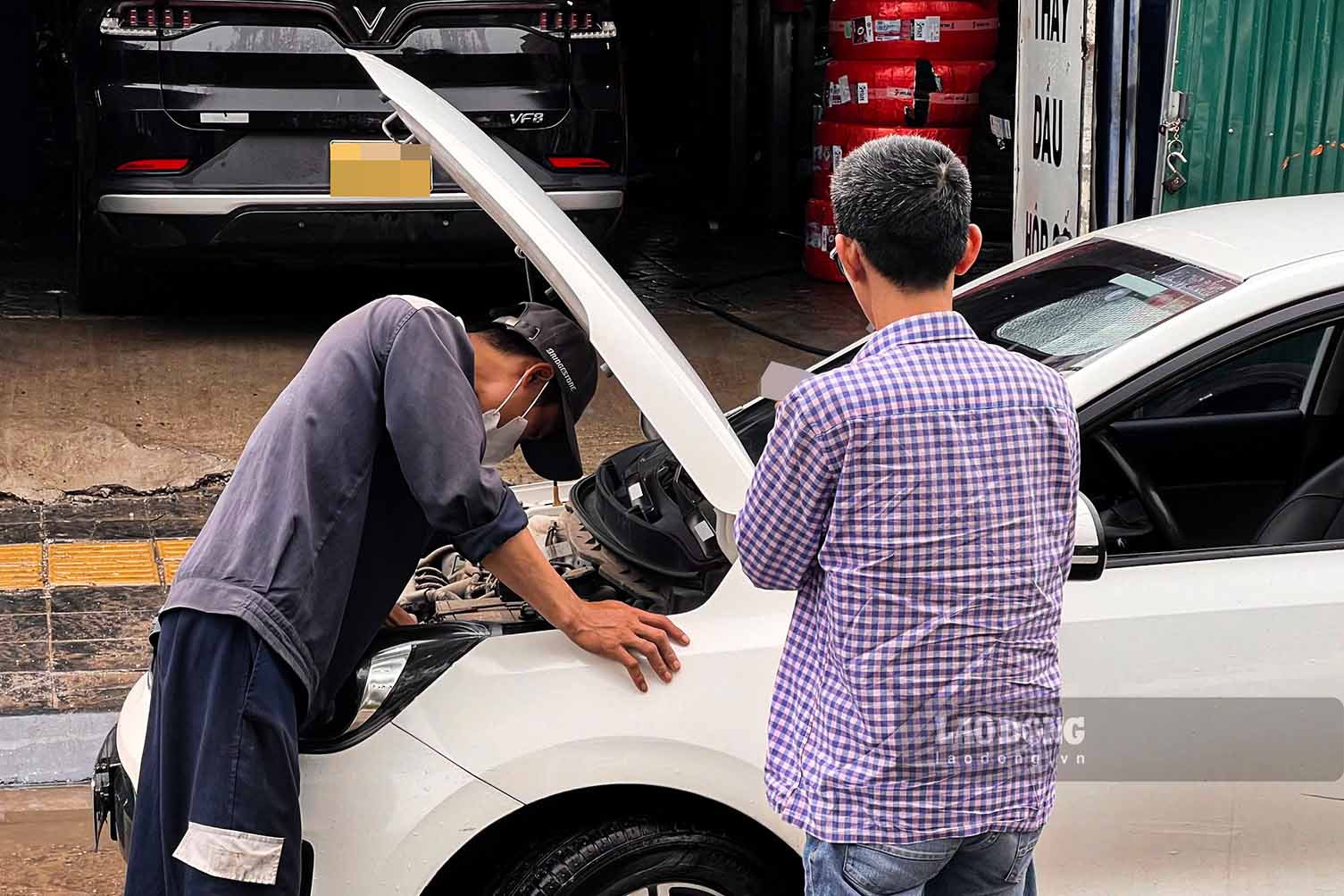 Anh Đặng Văn Long - kỹ thuật viên sửa chữa ôtô kiểm tra tình trạng phương tiện sau khi xe đã đi qua vùng ngập. Ảnh ngày 17.9: Hữu Vũ