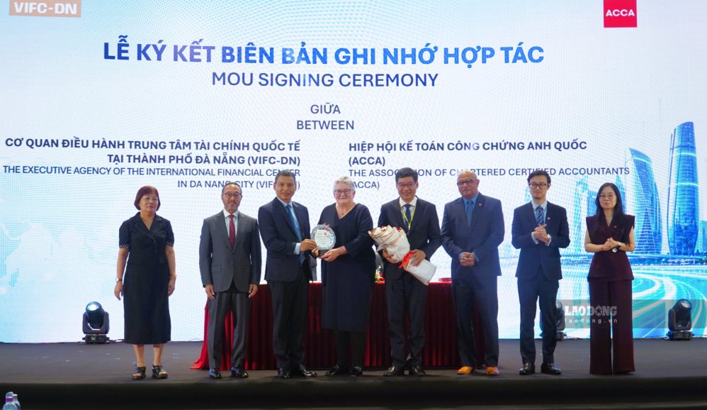 Representatives of the UK Chartered Accounting Association present flowers and commemorative medals to Da Nang leaders at the forum. Photo: Hoang Bin