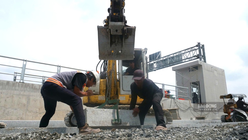 Công nhân khẩn trương thi công đường và vỉa hè hai bên cống ngăn triều Phú Định. Ảnh: Anh Tú