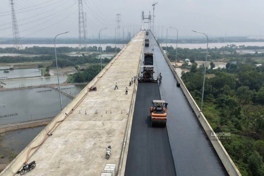 Đơn vị thi công đã bắt đầu rải những mét bê tông nhựa đầu tiên trên mặt cầu Phước Khánh. Các xe tải, máy rải và xe lu hoạt động liên tục trên mặt cầu, đường dẫn và các nhánh kết nối.