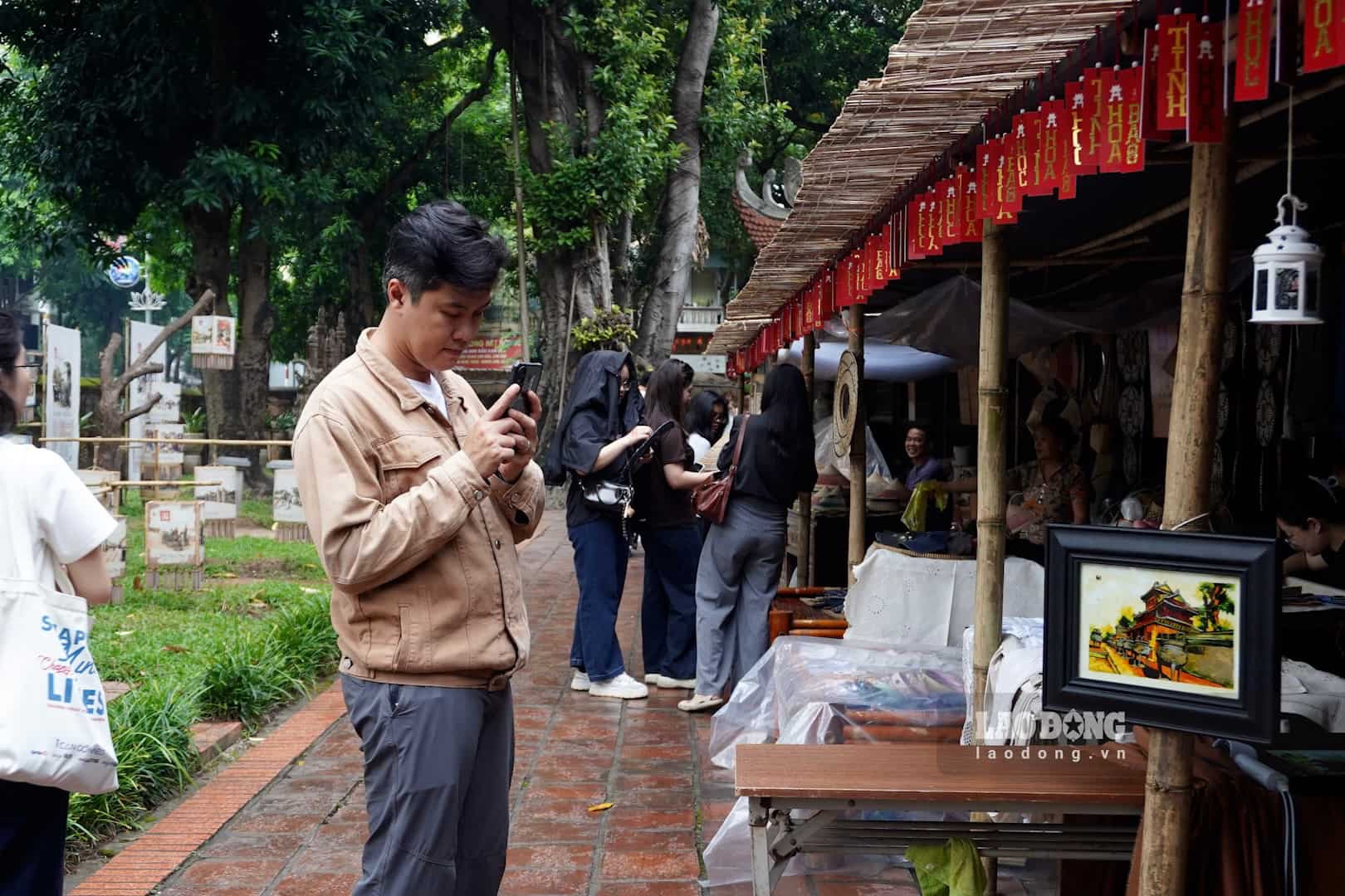 Turistas visitan y aprenden sobre los productos expuestos en el programa. Foto: Thai Trang ( tomada en septiembre de 2026)