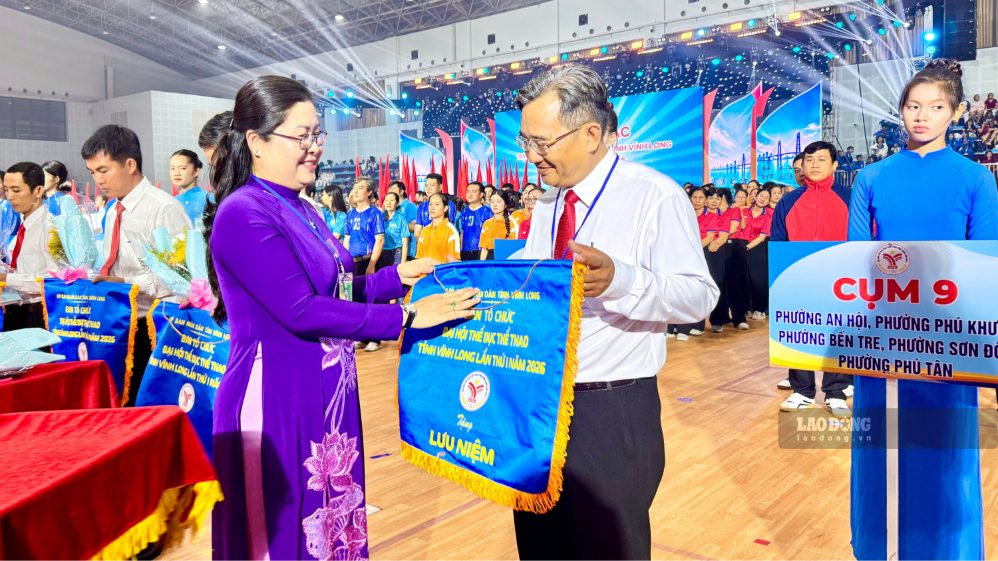 Bà Nguyễn Thị Minh Trang - Ủy viên Ban Thường vụ Tỉnh ủy, Trưởng Ban Tuyên giáo Tỉnh ủy - trao cờ lưu niệm, hoa chúc mừng các đơn vị tham gia Đại hội Thể dục thể thao tỉnh Vĩnh Long lần thứ I năm 2026. Ảnh chụp ngày 19.9.2026 tại lễ khai mạc. Ảnh: Hoàng Lộc
