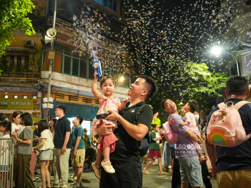 Gia đình anh Nguyễn Văn Tuyến, . Đây là năm thứ hai liên tiếp anh đưa con đến khu phố này chơi Trung thu. Do lượng khách đông, họ loay hoay chọn được góc chụp ưng ý.  “Tôi tranh thủ cuối tuần đưa vợ con đi chơi, chứ đúng lễ Trung thu chắc bị chen lấn không đi nổi“,