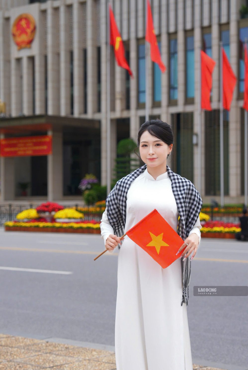Hàng cờ đỏ trước Tòa nhà Quốc hội tạo phông nền nổi bật, thu hút nhiều người trẻ diện áo dài đến chụp ảnh.