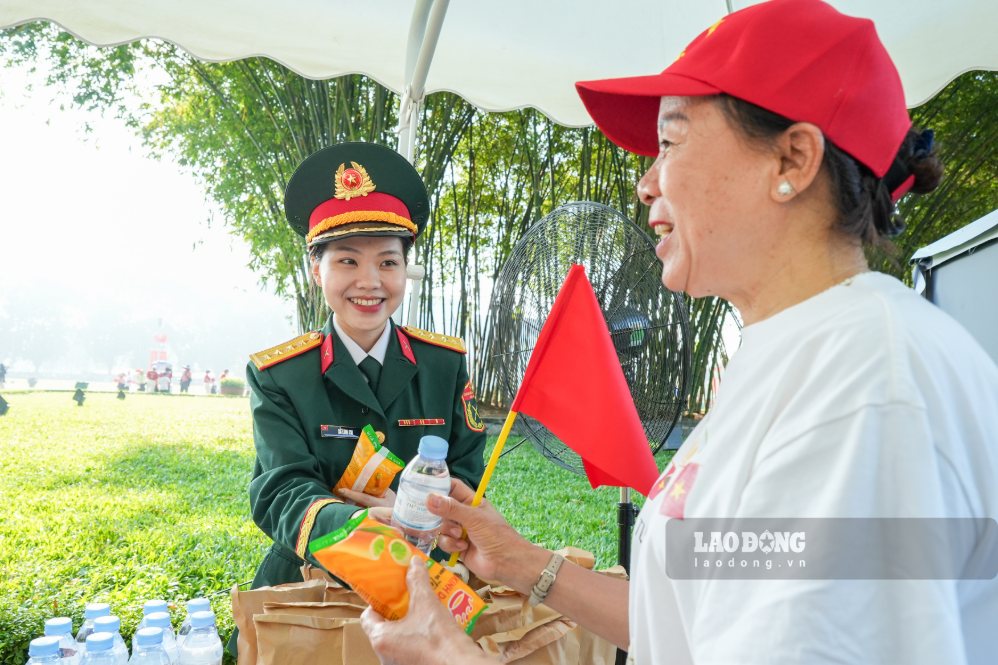 Lực lượng chức năng phát bánh, nước cho người dân vào Lăng viếng Bác ngày 2.9. Ảnh: Sóng Hữu 
