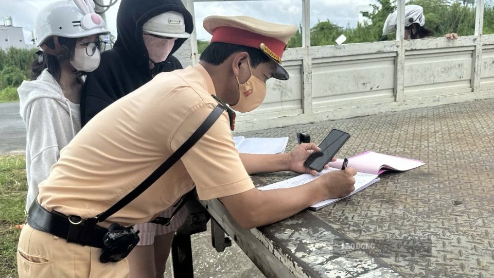 Traffic police handle speeding violations in a densely populated area on 3/2 street, Cai Von ward, Vinh Long province. Photo: Hoang Loc