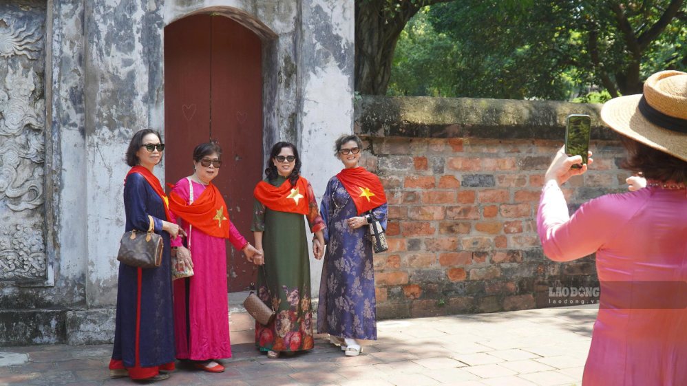 Du khách mặc áo dài chụp ảnh tại Văn Miếu. Ảnh: Minh Chính