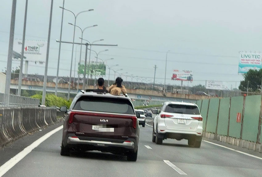 Hình ảnh nữ tài xế để trẻ nhỏ thò đầu khỏi cửa sổ trời khi ôtô chạy trên cao tốc. Ảnh: Cục CSGT cung cấp