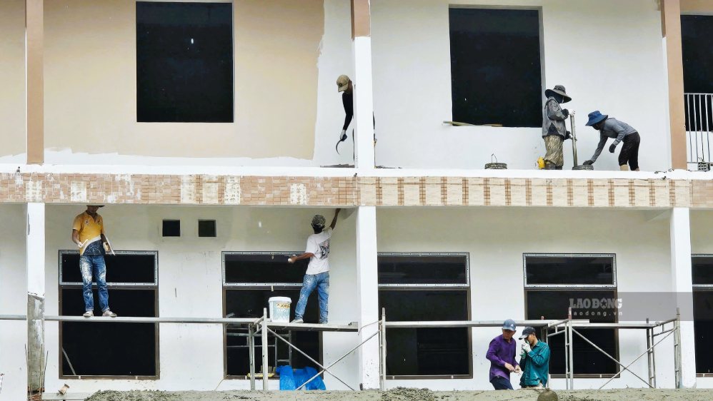 Công nhân gấp rút thi công, hoàn thiện khối nhà 3 tầng, gồm 30 lớp học để bàn giao cho nhà trường đón gần 950 học sinh vùng cao trong lễ khai giảng. Ảnh: Nguyễn Hoàng