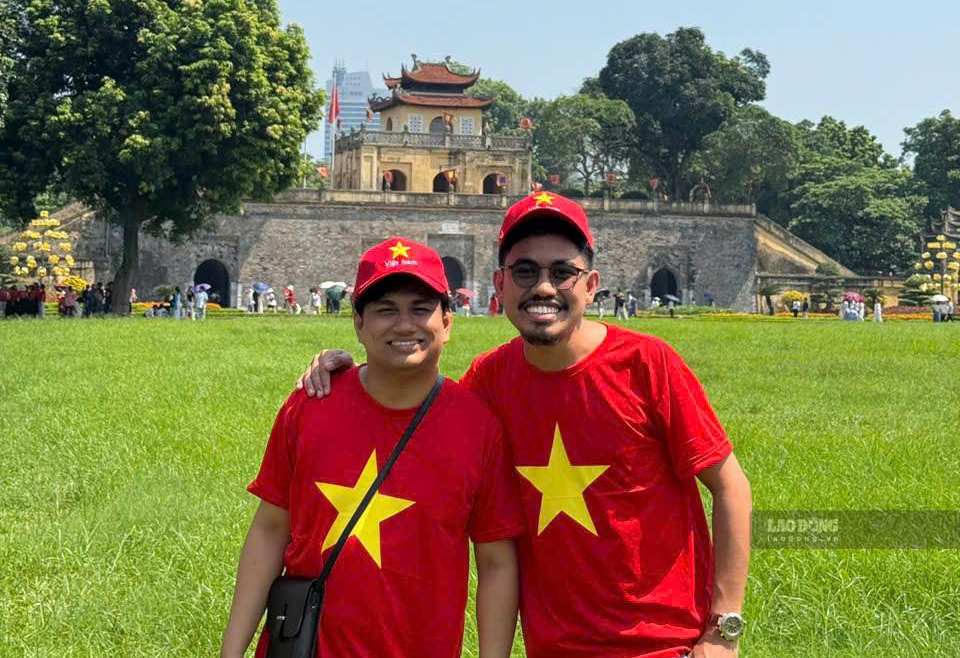 International visitors wearing red star yellow flag shirts check-in at Thang Long Imperial Citadel. Photo: I La