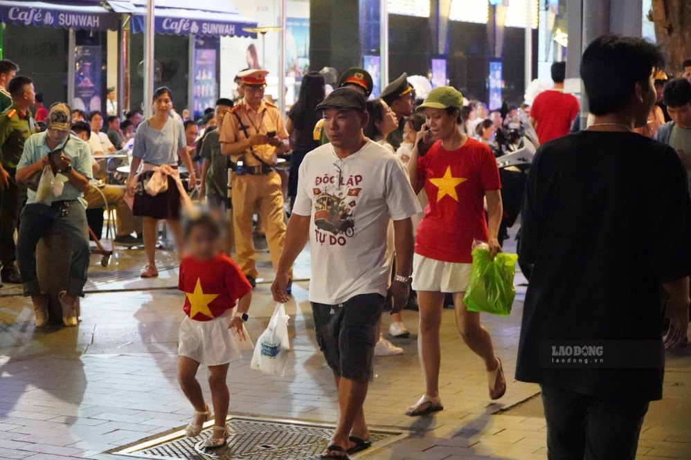 Người dân diện áo đỏ sao vàng, mang theo cờ Tổ quốc hòa vào không khí ngày hội. Ảnh: Anh Tú