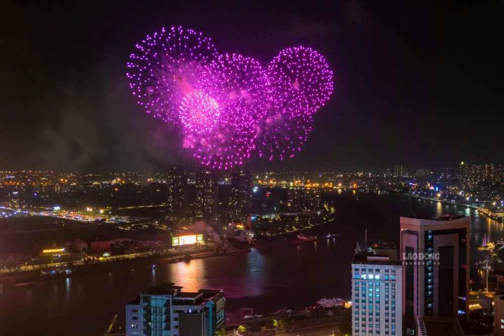 Pháo hoa phản chiếu xuống mặt sông Sài Gòn, tạo nên khung cảnh lung linh giữa lòng thành phố. Ảnh: Anh Tú