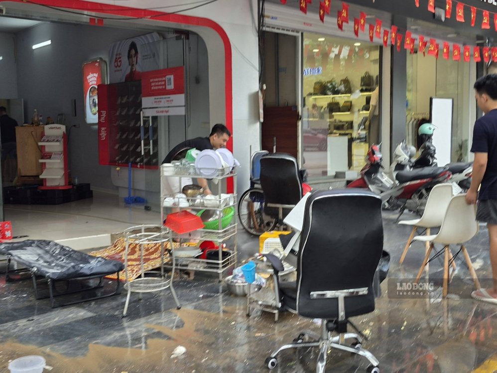 On the morning of September 20, people were busy cleaning and sanitizing the floors and belongings after the heavy rain caused flooding. Photo: Duy Chuong