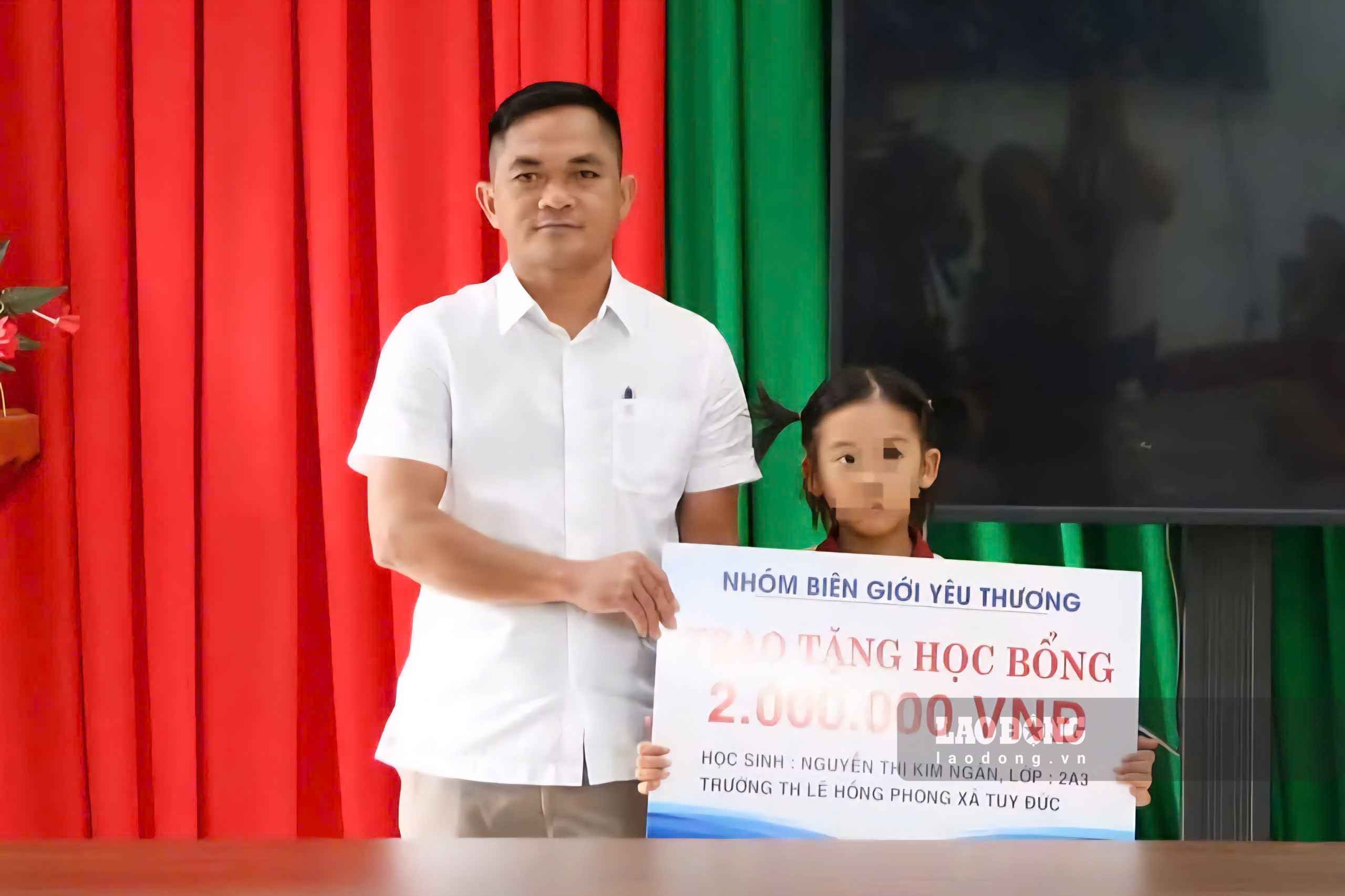 Ông Điểu Hùng, Phó Bí thư Thường trực Đảng ủy xã Tuy Đức trao học bổng tới cháu Nguyễn Thị Kim Ngân. Ảnh chụp ngày 16.9 (Ảnh: Nhi Nhi) 