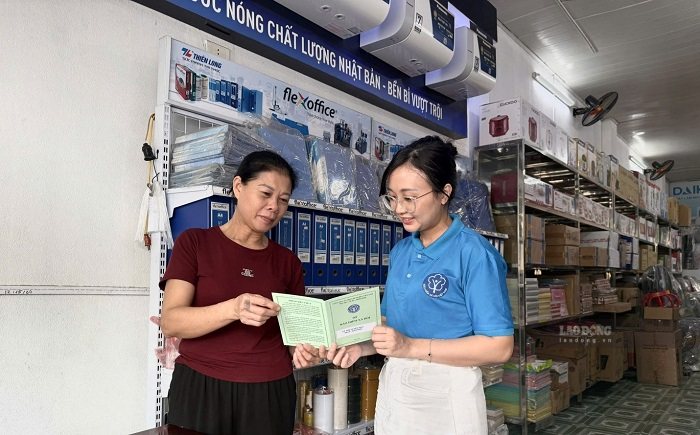 Bà Vũ Thị Tuyết Mai được cán bộ BHXH hướng dẫn đóng BHXH. Ảnh: Thục Vinh