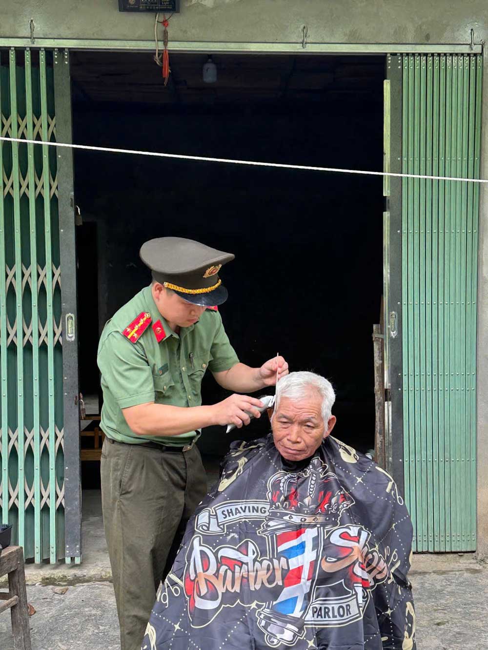 Cán bộ Công an xã Gia Hội trực tiếp cắt tóc miễn phí cho người cao tuổi. Ảnh: Công an tỉnh Lào Cai