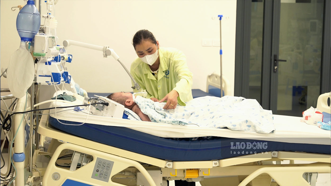 Taking advantage of the weekend, Ms. Phan Thi Viet Chinh went to the hospital to take care of her child with cerebral palsy. Photo: Linh Anh