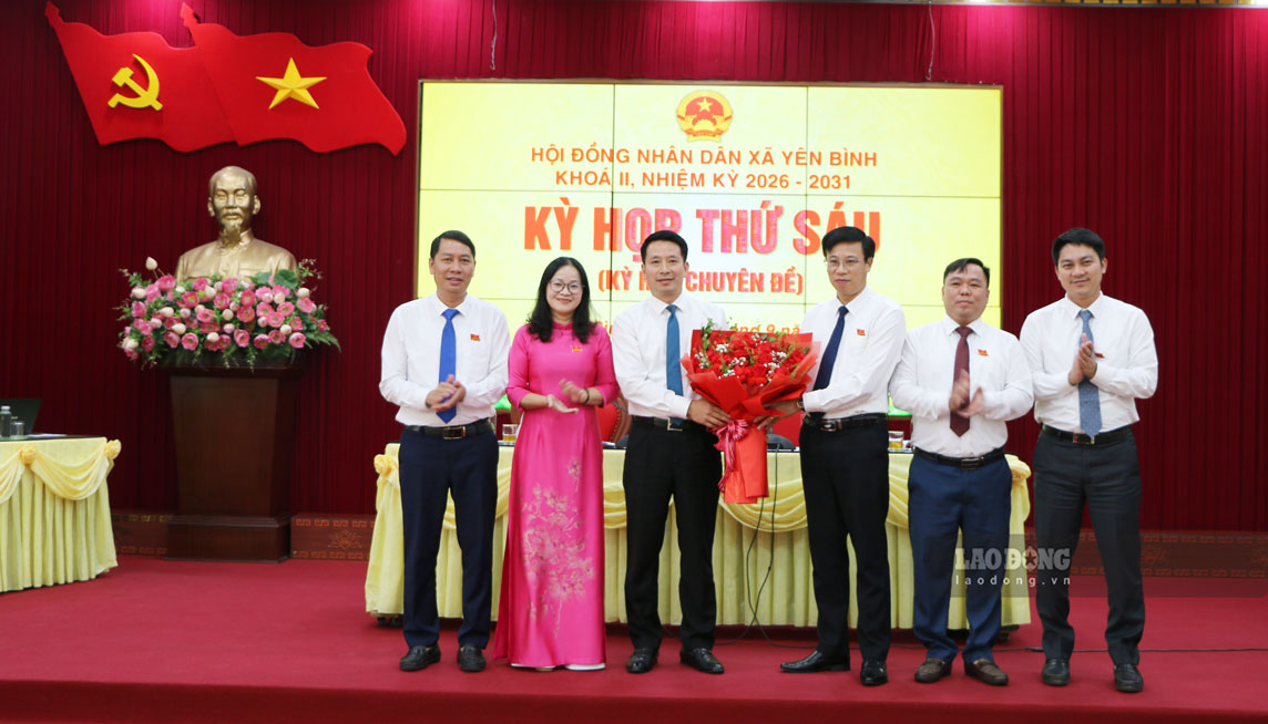 Lãnh đạo HĐND xã Yên Bình tặng hoa chúc mừng tân Chủ tịch UBND xã Bùi Ngọc Hùng. Ảnh: Thanh Thủy