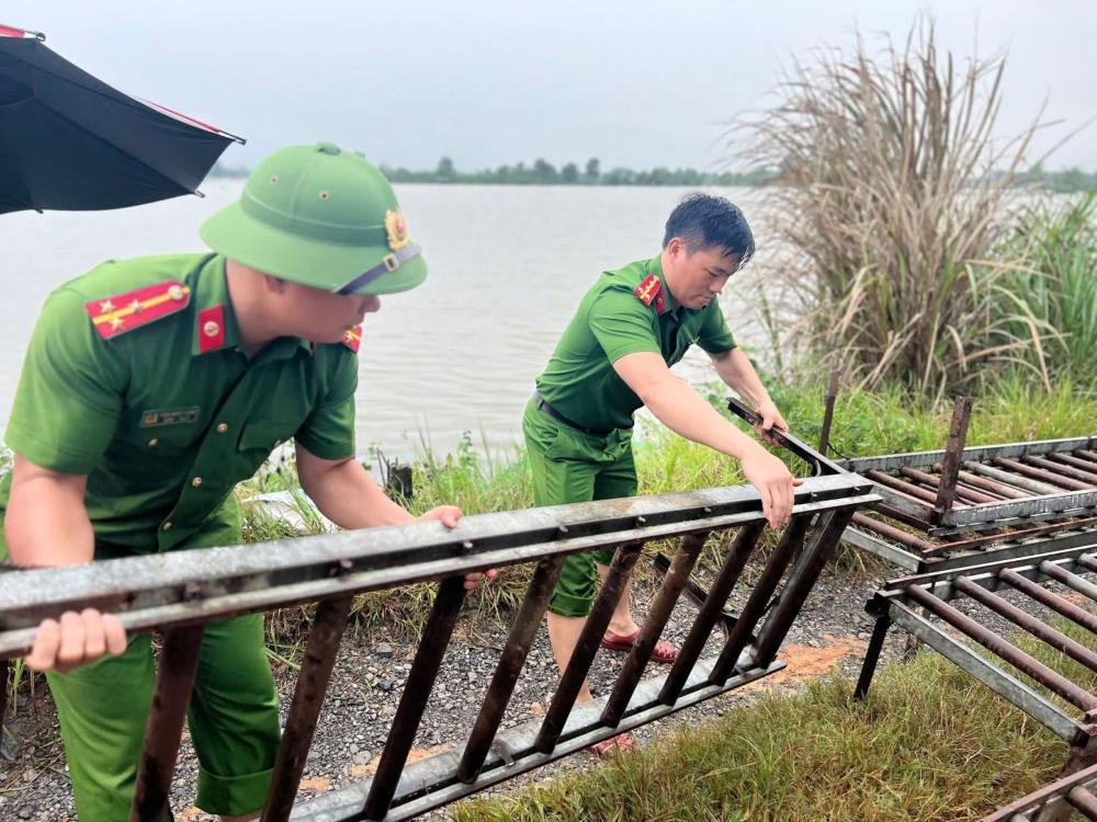 Công an xã Yên Trường (Thanh Hóa) tham gia lắp băng chuyền bằng sắt để di chuyển khoảng 45.000 con gà khỏi vùng ngập. Ảnh: Công an Thanh Hóa