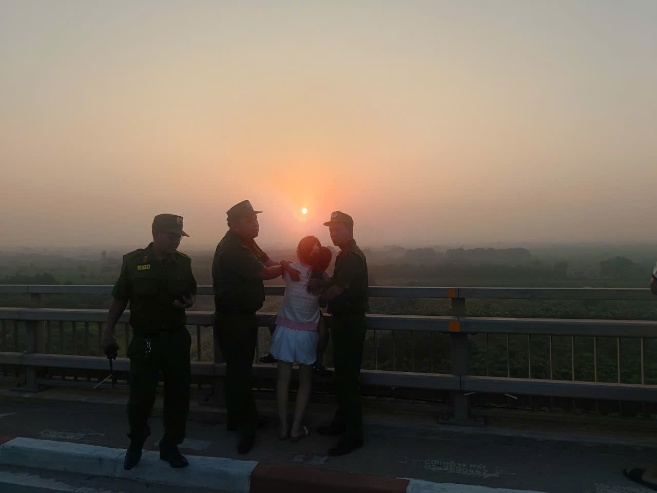 The working group persistently persuaded the woman to give up her suicidal idea at Nhat Tan bridge. Photo: Hanoi City Police