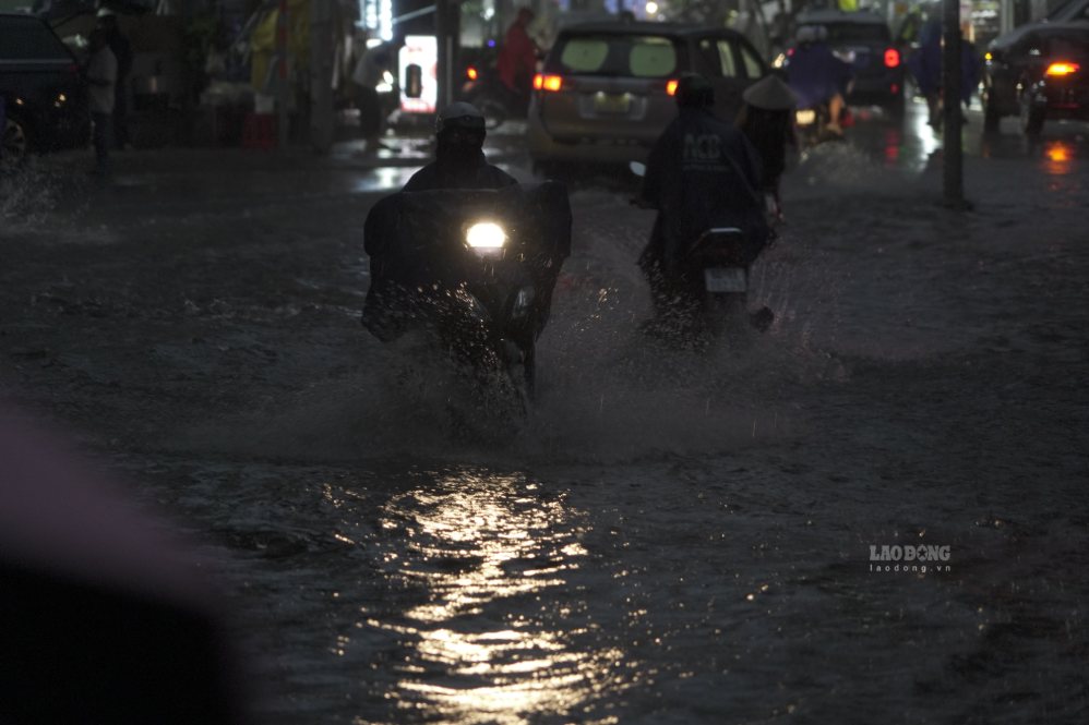 Rain poured down at rush hour, causing many people to struggle to wade through water in the late afternoon of September 22. Photo: Thai Bao