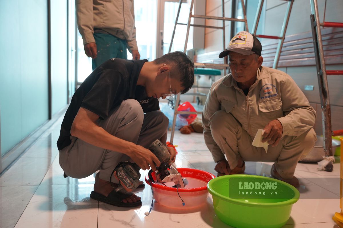 Công nhân tháo dỡ để vệ sinh điều hòa tại phòng bệnh. Ảnh: Lương Hà