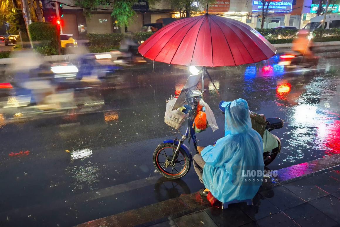 Bất kể thời tiết xấu, nhiều người vẫn đi bán vé số mưu sinh. Ảnh: Tạ Quang (ảnh chụp ngày 22.9)