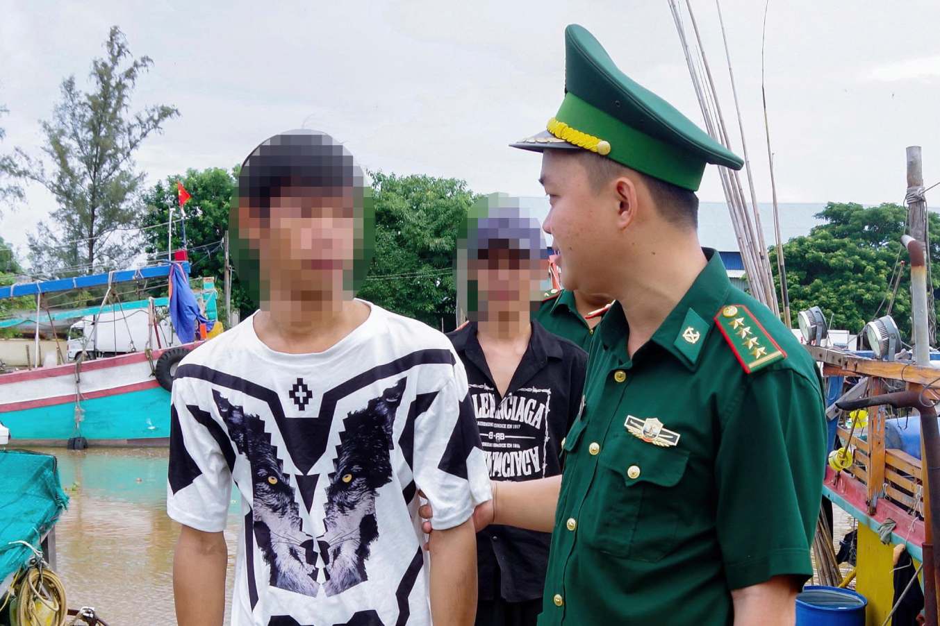 Cán bộ đồn Biên phòng Trung Bình tiếp nhận ngư dân gặp nạn. Ảnh: Quân khu 9