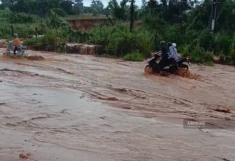 Dòng nước với lực chảy mạnh gây khó khăn cho các xe máy lưu thông, chiều 23.9. Ảnh: Duy Tuấn 