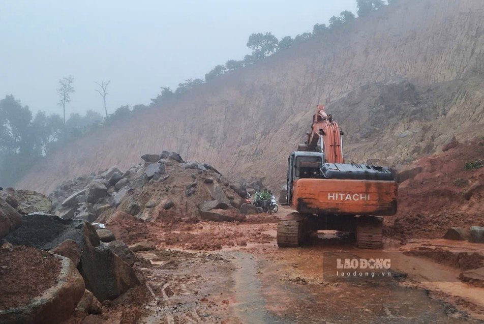 Máy múc được huy động tới hiện trường, nhưng do trời đang mưa lớn chưa thể khắc phục sạt lở. Ảnh: Phúc Khánh