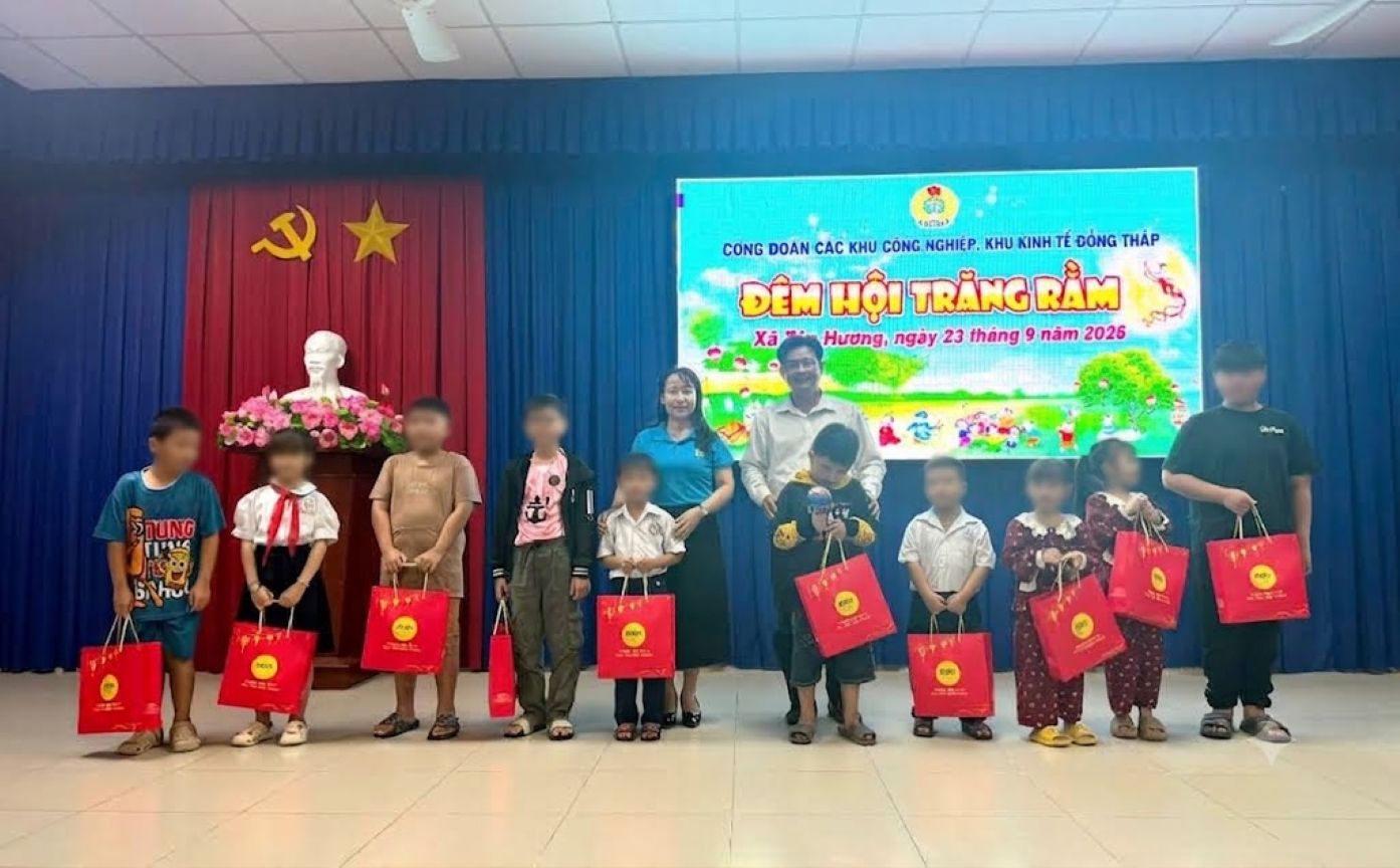 Bà Ngô Thị Thùy Trang (thứ nhất hàng sau từ trái sang) trao quà Trung thu cho các cháu. Ảnh: Thanh Nhàn